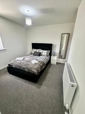 a bedroom with a bed and a mirror at Newly refurbed 3 bed home 15mins to Edin city in Livingston