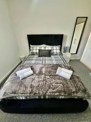 a bedroom with a large bed with two pillows at Newly refurbed 3 bed home 15mins to Edin city in Livingston