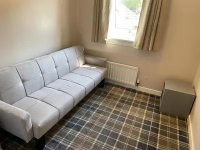 a white couch in a room with a window at Bespoke home in Kirky in Kirknewton