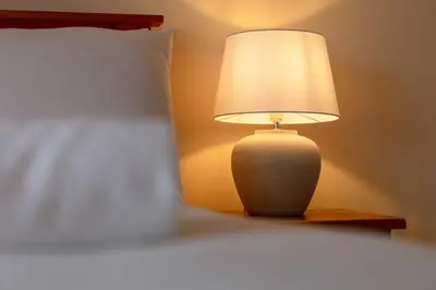a lamp sitting on a table next to a bed at The Portland Penthouse - Donnini Apartments in Troon