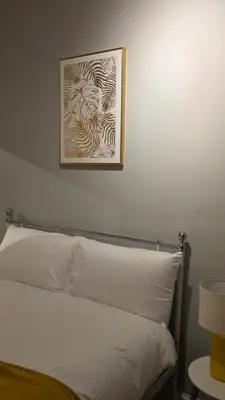 a bed with a picture on the wall above it at ANSI Splendor in Livingston