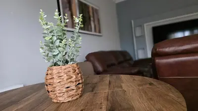 a wooden table with a vase with flowers on it at ANSI Splendor in Livingston