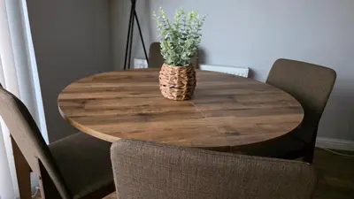 a wooden table with a vase with a plant on it at ANSI Splendor in Livingston