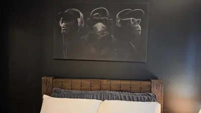 a bedroom with a painting of masks on the wall at ANSI Splendor in Livingston
