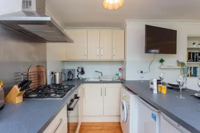 a kitchen with white cabinets and a stove top oven at Free Parking - City Centre - 3 Bedrooms - 5 Guests in Edinburgh