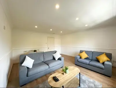 a living room with a couch and a table at Spacious 2 Bed Apartment Near Glasgow Airport in Glasgow