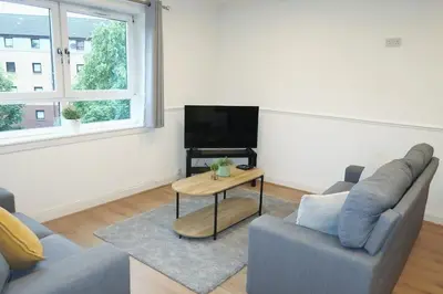 a living room with a couch and a table at Spacious 2 Bed Apartment Near Glasgow Airport in Glasgow