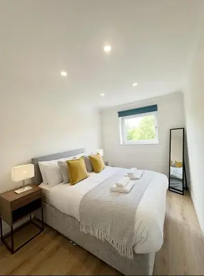 a white bedroom with a large bed and a window at Spacious 2 Bed Apartment Near Glasgow Airport in Glasgow