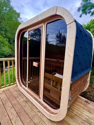 a large glass door on a wooden deck at 60 Mile Inn - Luxury Pods with Hot Tubs in Bridge of Orchy