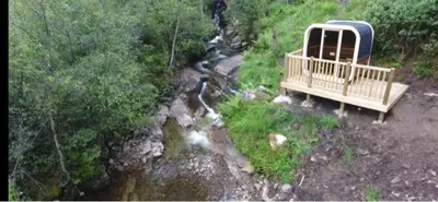 an aerial view of a boat and a river at 60 Mile Inn - Luxury Pods with Hot Tubs in Bridge of Orchy