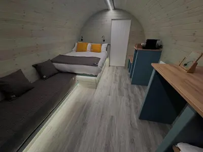 a small room with a bed and a couch at 60 Mile Inn - Luxury Pods with Hot Tubs in Bridge of Orchy