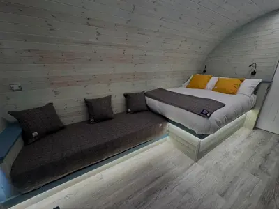 a small room with a bed and a couch at 60 Mile Inn - Luxury Pods with Hot Tubs in Bridge of Orchy