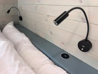 a bed with a headboard with a headphone on it at 60 Mile Inn - Luxury Pods with Hot Tubs in Bridge of Orchy