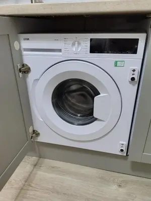 a white washing machine in a cabinet in a kitchen at Millburn Chalet in Inverkip