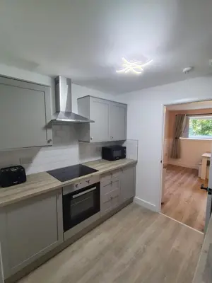 a kitchen with white cabinets and a stove top oven at Millburn Chalet in Inverkip