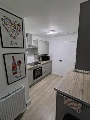 a kitchen with white cabinets and a counter top at Millburn Chalet in Inverkip