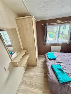 a small room with a bed and a cabinet at Four-bed Delta Caravan, Uddingston, Glasgow Located in Uddingston, Glasgow at Maryville Caravan Site in Uddingston