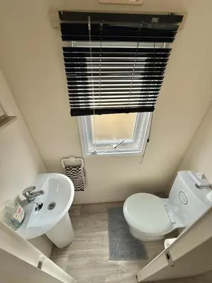 a bathroom with a toilet and a sink and a window at Four-bed Delta Caravan, Uddingston, Glasgow Located in Uddingston, Glasgow at Maryville Caravan Site in Uddingston