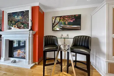 a dining room with a table and two chairs and a fireplace at The Allanbreck Studio Glencoe Ballachulish Highlands Near Fortwilliam in Glencoe