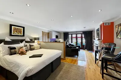 a bedroom with a large bed with a teddy bear on it at The Allanbreck Studio Glencoe Ballachulish Highlands Near Fortwilliam in Glencoe