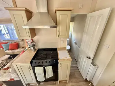 a kitchen with a stove top oven in a room at Deluxe Delta 4-Bedroom Caravan Located at Maryville Caravan Site Uddingston, Glasgow in Uddingston