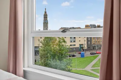 a window with a view of a clock tower at Modern 2-Bedroom flat in Glasgow city centre, near Galsgow Green in Glasgow