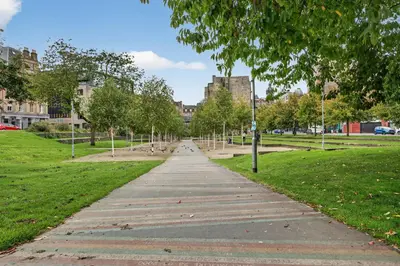 a walkway in a park with trees and buildings at Modern 2-Bedroom flat in Glasgow city centre, near Galsgow Green in Glasgow