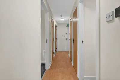 a hallway with white walls and wooden floors at Modern 2-Bedroom flat in Glasgow city centre, near Galsgow Green in Glasgow