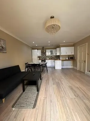 a living room with a black couch and a table at Walker Apartment in Edinburgh