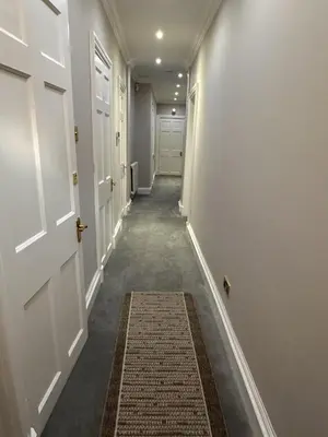 a hallway with white doors and a rug at Walker Apartment in Edinburgh