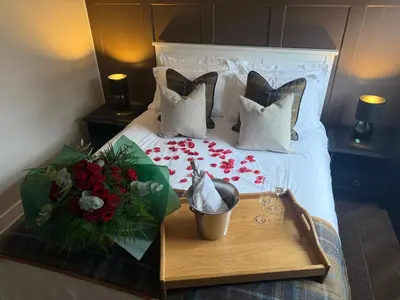 a bedroom with a bed with a tray with flowers at Luxury Old Town Apartment just a 5 Minute Walk to Stirling Castle in Stirling