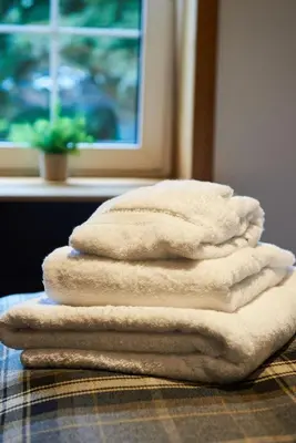 a stack of towels sitting on top of a table at Luxury Old Town Apartment just a 5 Minute Walk to Stirling Castle in Stirling