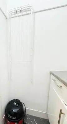 a white kitchen with a black toaster in the corner at Stylish Flat in Historic Edinburgh city centre home in Edinburgh