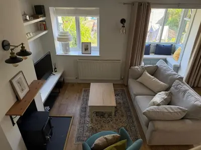 a living room with a couch and a table at Cosy Cottage in Cotswolds in Moffat