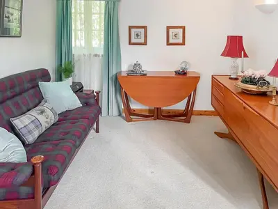 a living room with a couch and a table at Tigh An Droma Lodge in Whiting Bay