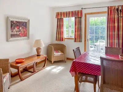 a living room with a table and chairs and a window at Tigh An Droma Lodge in Whiting Bay