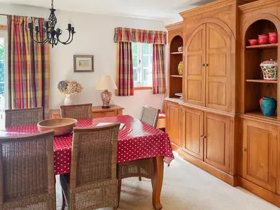 a dining room with a red table and chairs at Tigh An Droma Lodge in Whiting Bay