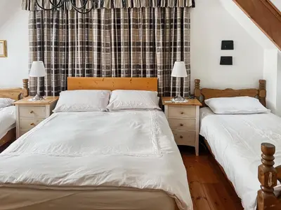 a bedroom with two beds and two night stands at Tigh An Droma Lodge in Whiting Bay