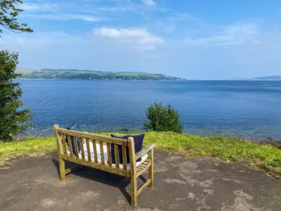 a wooden bench sitting on the side of a body of water at Thornlie - Uk49875 in Blairmore
