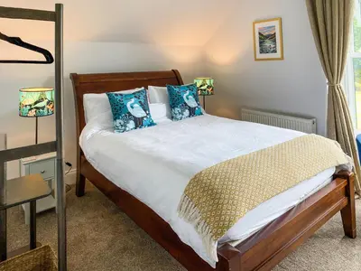 a bedroom with a bed with blue pillows at Thornlie - Uk49875 in Blairmore