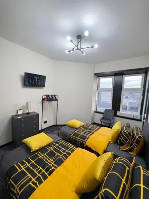 two beds in a room with yellow and black sheets at 3BR West End Flat w Free Parkin in Glasgow