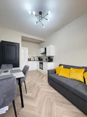 a living room with a black couch and a table at 3BR West End Flat w Free Parkin in Glasgow