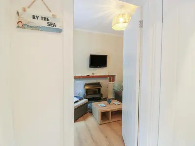 a hallway with a living room with a fireplace at Cosy In in Millport