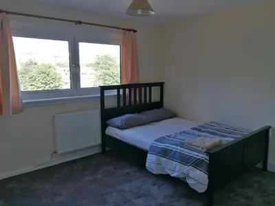 a bedroom with a bed and a window at Three Bedroom Apartment Glasgow in Glasgow