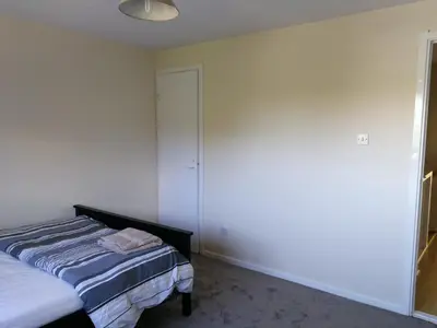 a bedroom with a bed and a white wall at Three Bedroom Apartment Glasgow in Glasgow