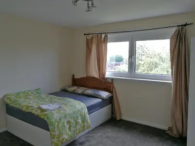 a small bedroom with a bed and a window at Three Bedroom Apartment Glasgow in Glasgow