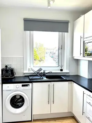 a kitchen with a washing machine and a window at Newtown Hideaway in Boʼness