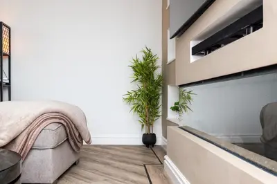 a bedroom with a fireplace and plants in it at 2 Bedroom House-Free Parking in Rosyth