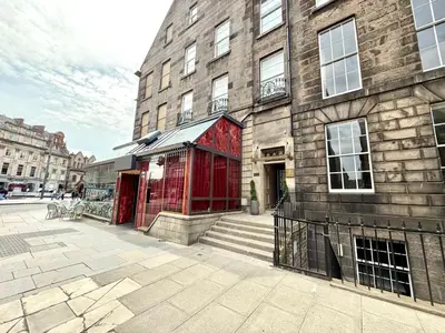 a brick building with a red door next to a building at Prime Central Edinburgh 1 bed in Edinburgh