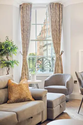 a living room with a couch and a chair and a window at Prime Central Edinburgh 1 bed in Edinburgh